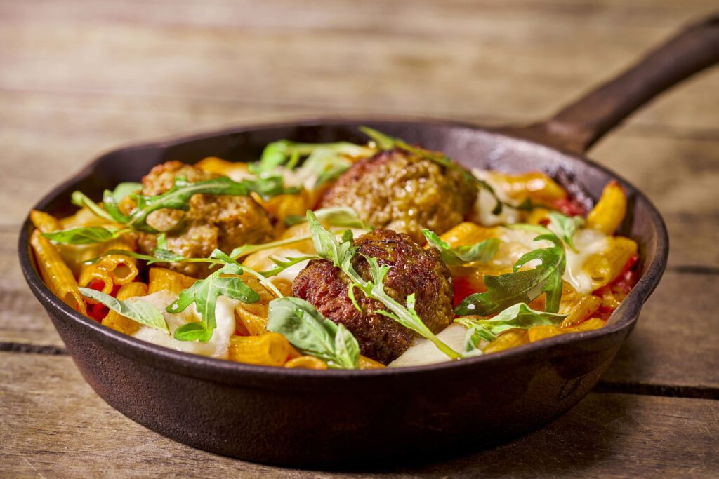 RECEPT Spicy kalfsgehaktballen met penne, mozzarella, tomaat, rucola en basilicum